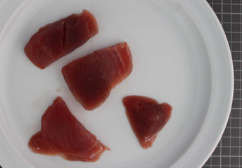 das Bild zeigt rohe, dunkelrote Stücke von Thunfischfilet